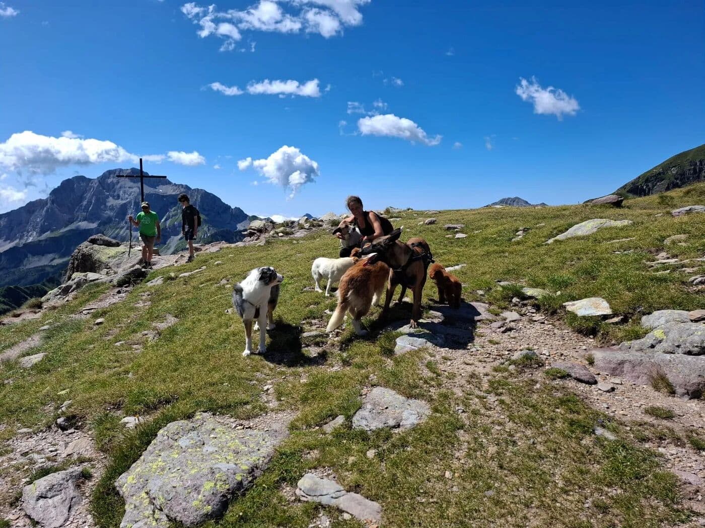 Daniela in montagna con i suoi cani, sotto un cielo azzurro